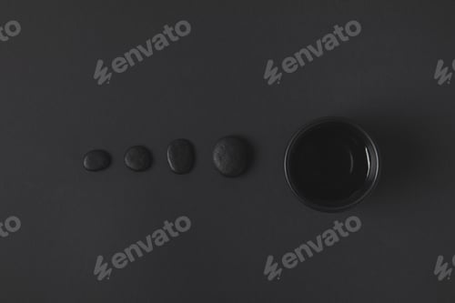 Preview: top view of chinese tea cup and pebbles on black surface