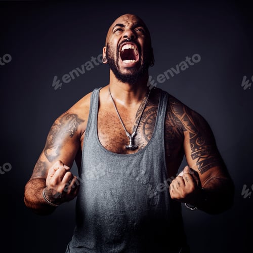 Preview: Muscular black man yelling with enraged attitude in a studio shot on dark background