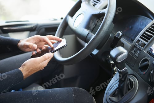 Preview: Man using smartphone in car