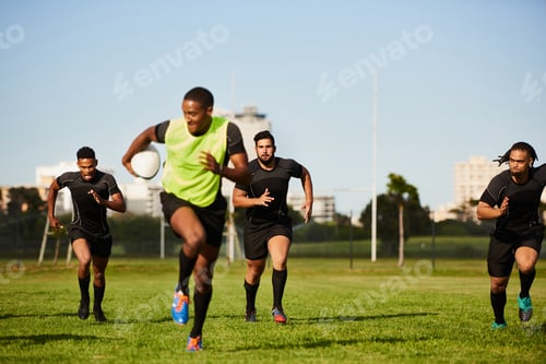 Preview: Full length shot of a diverse group of sportsmen playing a game of rugby during the day