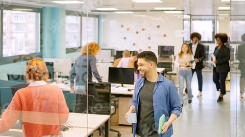 Preview: Coworkers arriving at the office and sitting on desk