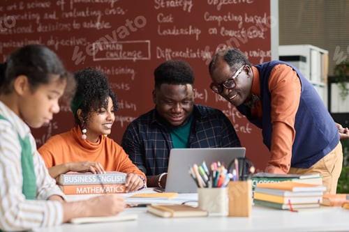 Preview: Smiling Black Teacher Helping Students Working on Group Project and Using Laptop