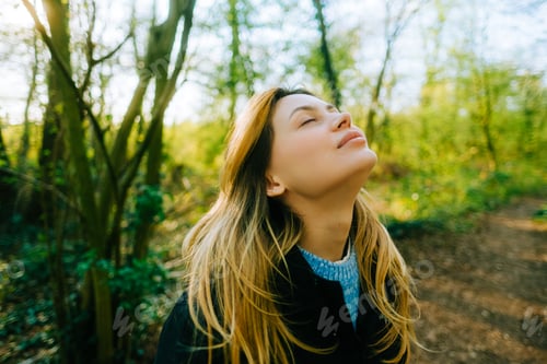 Preview: Attractive caucasian woman breathe fresh air , enjoying springtime on a sunset in natural parkland