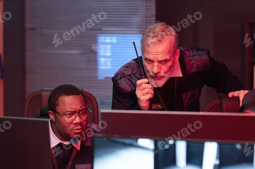 Preview: Middle Aged Caucasian Man Instructing Young Adult Black Man Using Walkie Talkie