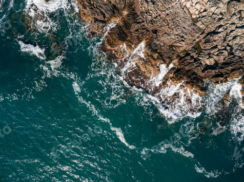 Preview: Aerial view of foam and rock waves.