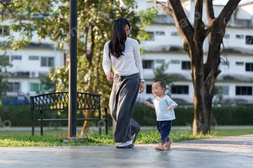 Preview: Mother and child walking together in park enjoying time