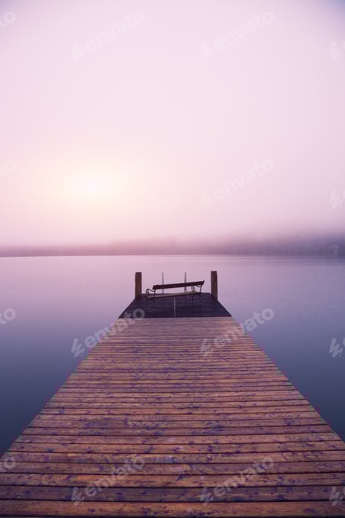 Preview: Empty footbridge with a bench on a lake Altausseer at sunrise