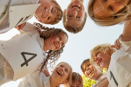 Preview: Low angle view of boy and girl sport team huddled in circle