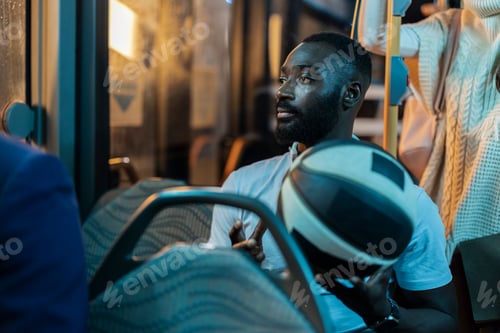 Preview: Young black man commuting by bus at night holding basketball