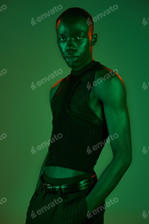 Preview: Young african american man showcasing vibrant style in bold neon green light setting