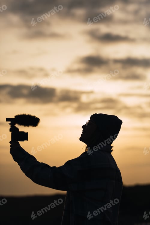 Preview: Anonymous happy lady recording vlog on camera under sundown sky