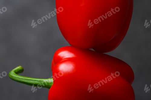 Preview: Two red peppers on a grey table