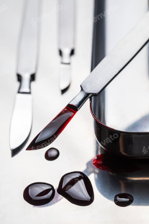 Preview: Stainless steel scalpels with blood on stainless steel plate.