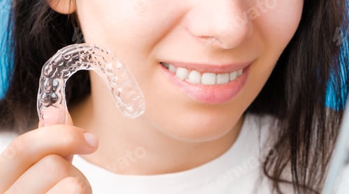 Preview: Close up woman holding a transparent removable braces for perfect smile. Orthodontic aligners for