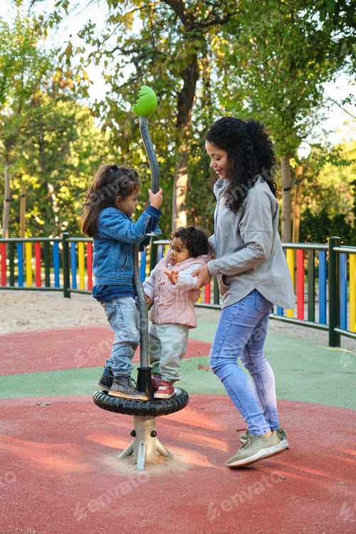 Preview: Dominican mother playing with her children at the synchro spinner in a park.
