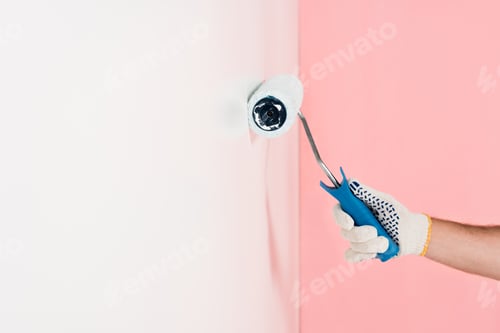 Preview: partial view of man in protective glove painting wall in white by paint roller