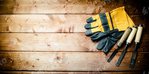 Preview: Chisel with construction gloves on the table.