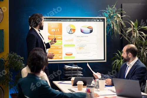 Preview: General director showing statistics data on interactive board in a conference
