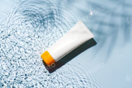 Preview: Tropical setting with a skincare tube resting on textured white surface illuminated by sunlight
