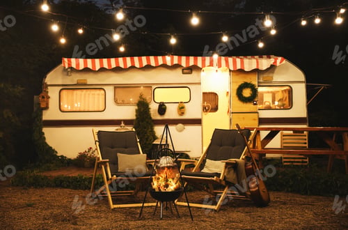 Preview: Water heating on open fire near trailer at night. Camping season