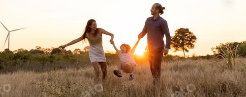 Preview: Family with son walking on field on wind farm.