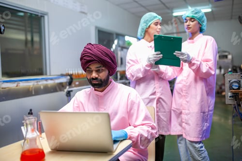 Preview: Asian scientists use test tube checking juice product in the beverage factory.