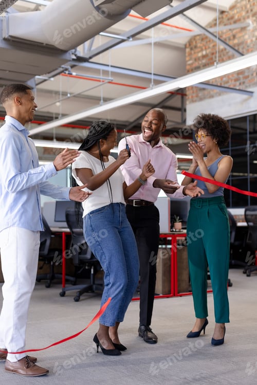Preview: Business team celebrating ribbon cutting ceremony in modern office, feeling excited