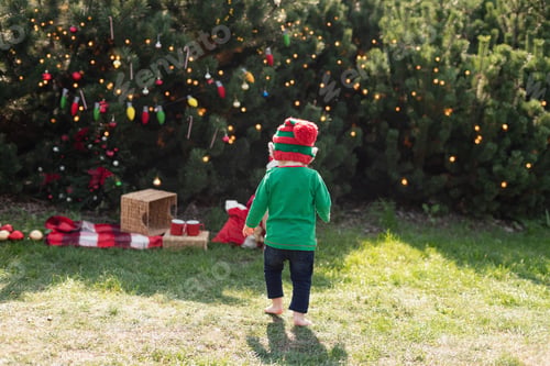 Preview: Christmas in july. Child waiting for Christmas in wood in july.