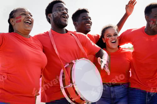 Preview: African red sport football fans celebrating team victory in soccer championship game at stadium crow