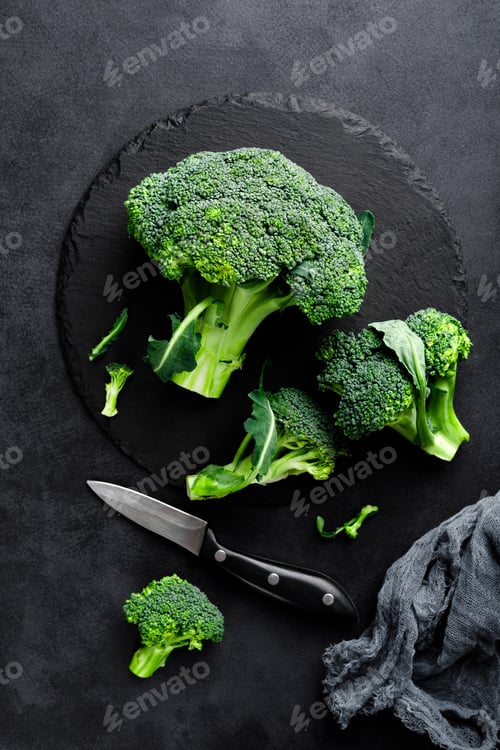 Preview: Fresh broccoli florets on black background, top view