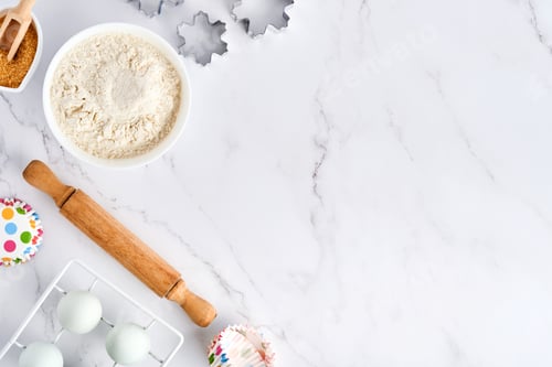 Preview: Baking background with flour, eggs, kitchen tools, utensils and cookie molds on white marble table.