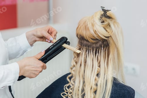 Preview: Hairdresser makes hairstyle close-up on blond hair of beautiful woman