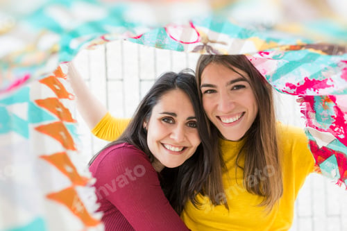 Preview: two beautiful women having fun outdoors at sunset with a handkerchief. City background. Lifestyle