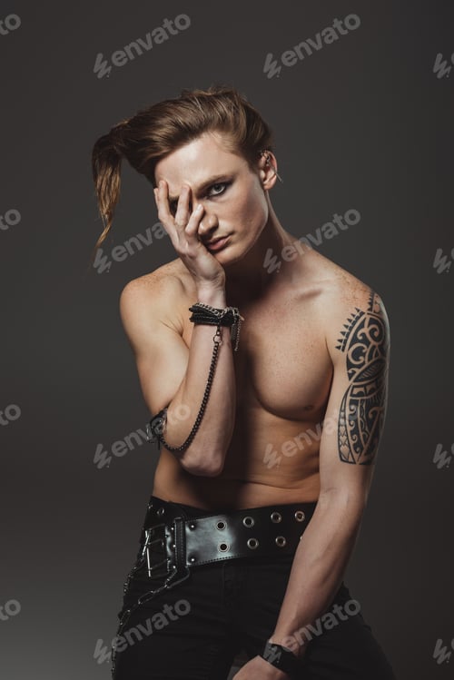 Preview: handsome shirtless man with tattoo on hand and strange hairstyle, isolated on grey