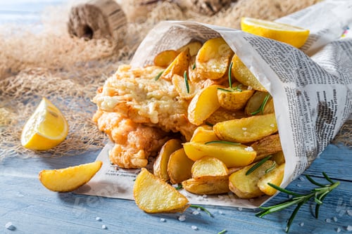 Preview: Fish cod with chips and lemon in newspaper