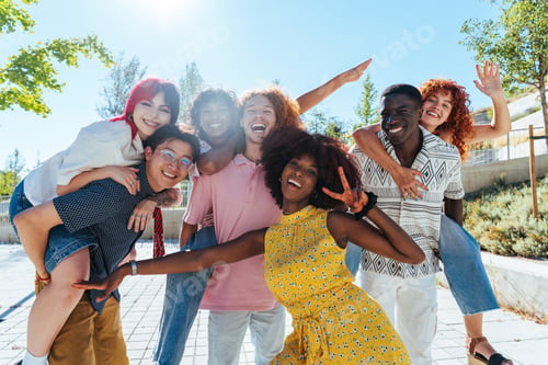 Preview: Multiethnic group of young friends meeting and having fun outdoors