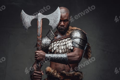 Preview: Fearful african soldier with axe stares at camera in dark background