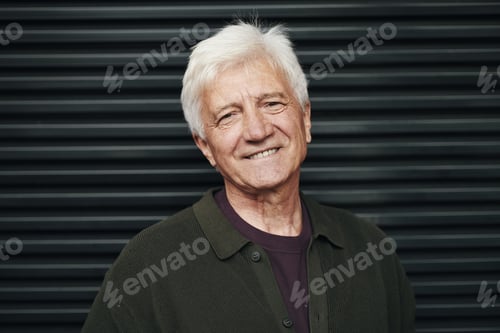 Preview: Portrait of Senior Man Smiling While Standing Against Black Wall