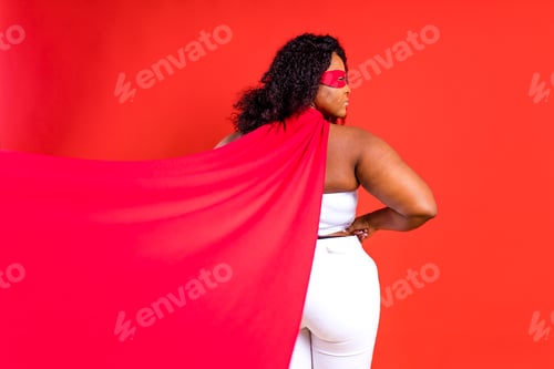 Preview: latin hispanic woman in red eye mask and long superhero cloak in studio background