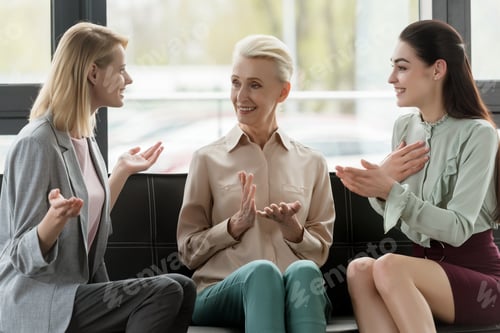 Preview: beautiful businesswomen gesturing while talking in office