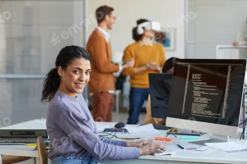 Preview: Ethnic Young Woman Programming Software in Office
