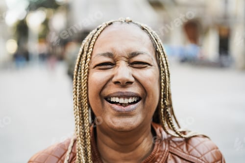 Preview: Senior african woman smiling on camera with city on background - Focus on mouth