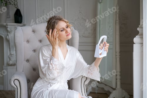 Preview: Woman Adjusting Her Hair While Holding Hand Mirror