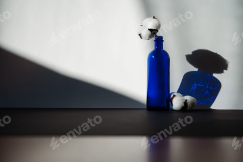 Preview: Blue glass bottle with two cotton flowers