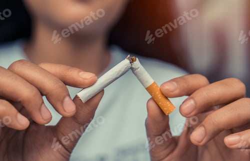 Preview: Cigarette.World No Tobacco Day Concept.Closeup woman holding broken cigarette in hands.
