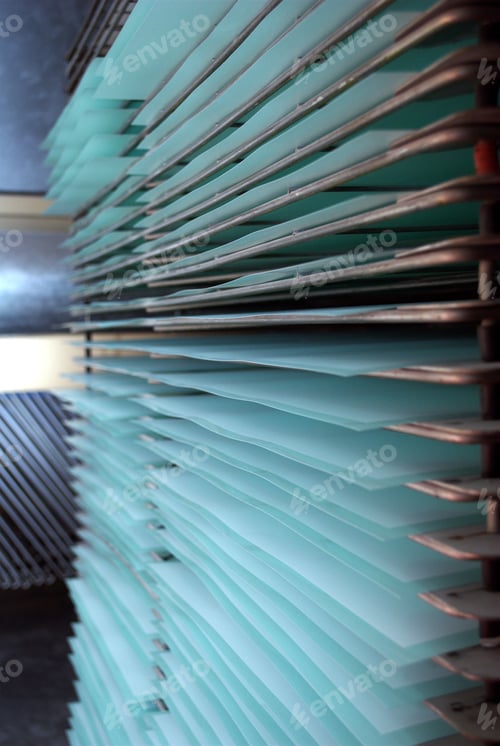 Preview: Vertical shot of sheets of paper on screen printers drying rack