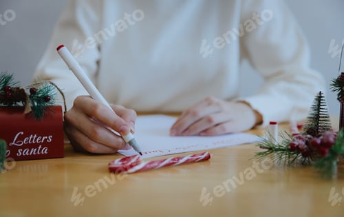 Preview: A teenage girl writes a letter to Santa Claus at the table.