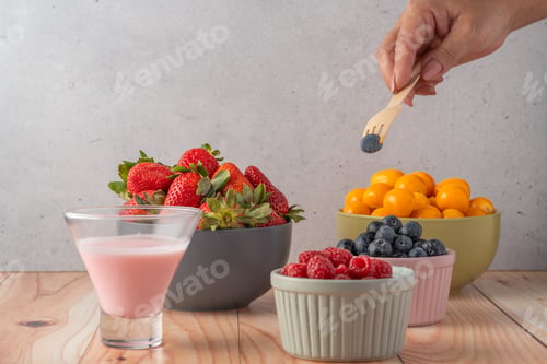 Preview: Person picking a blueberry from a bowl of healthy breakfast