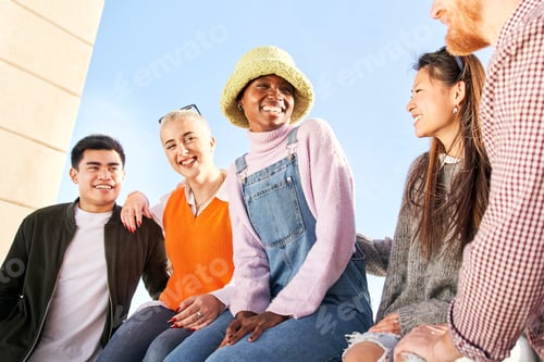 Preview: Multiracial group of diverse guys sitting outdoors having fun. Young multi-ethnic friends enjoying