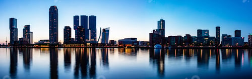 Preview: Rotterdam Netherlands skyline night panorama. City towers illuminated, reflections on the wate
